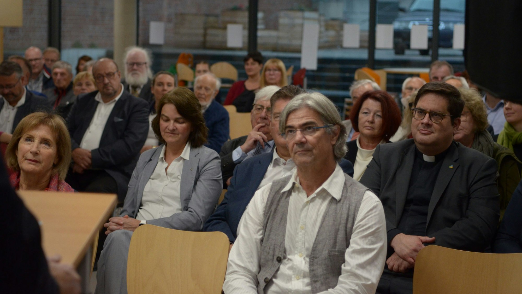 In der Aula der Gesamtschule Euskirchen sitzen in Stuhlreihen Männer und Frauen bei einer Gedenkfeier für den Widerstandskämpfer Willi Graf.