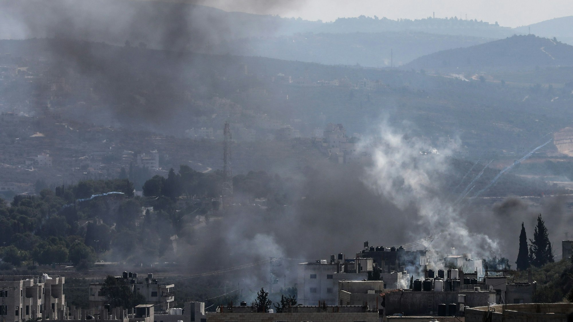 Palästinensische Gebiete, Nablus: Rauch, der von brennenden Reifen und Tränengasgranaten stammt, steigt am Freitag (13. Oktober) über Gebäuden auf, bei Zusammenstößen von Palästinensern mit israelischen Sicherheitskräften.