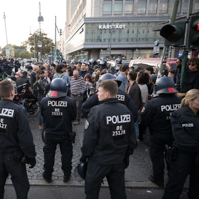 Polizeibeamte stehen in Berlin-Neukölln auf dem Hermannplatz vor einer Gruppe, aus der "Free Palestine"-Rufe kamen.