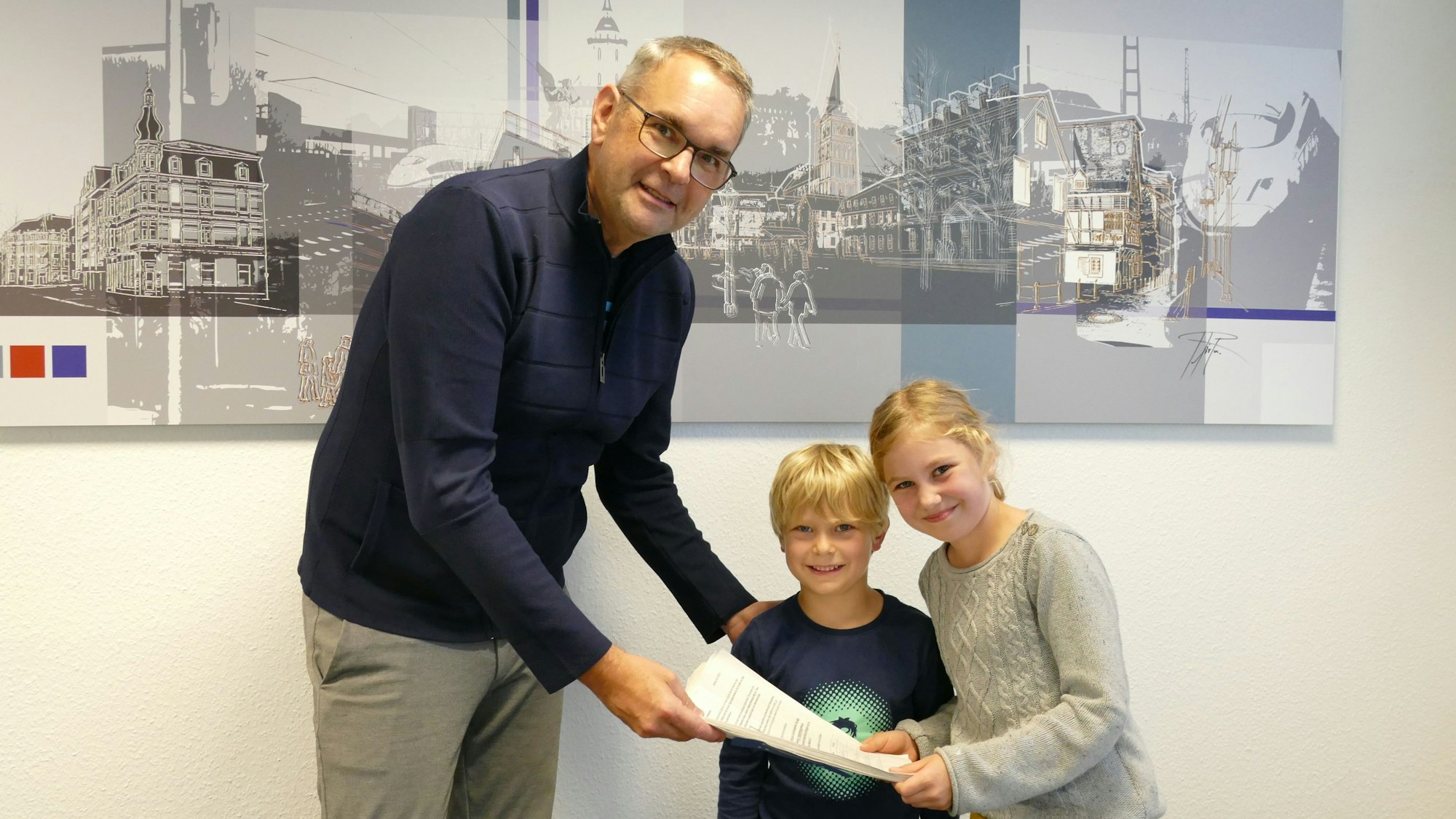 Zwei Kinder drücken einem Mann Unterschriften in die Hand.