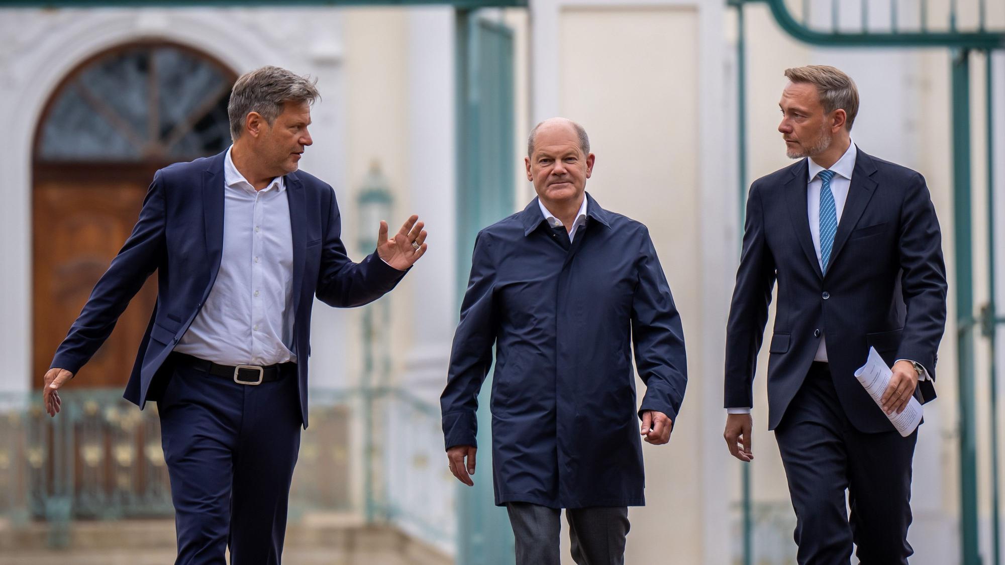 Bundeskanzler Olaf Scholz (SPD, M) kommt zwischen Christian Lindner (FDP, l), Bundesminister der Finanzen, und Robert Habeck (Bündnis 90/Die Grünen, r), Bundesminister für Wirtschaft und Klimaschutz, zum Pressestatement bei der Halbzeit-Klausur des Bundeskabinetts auf Schloss Meseberg.