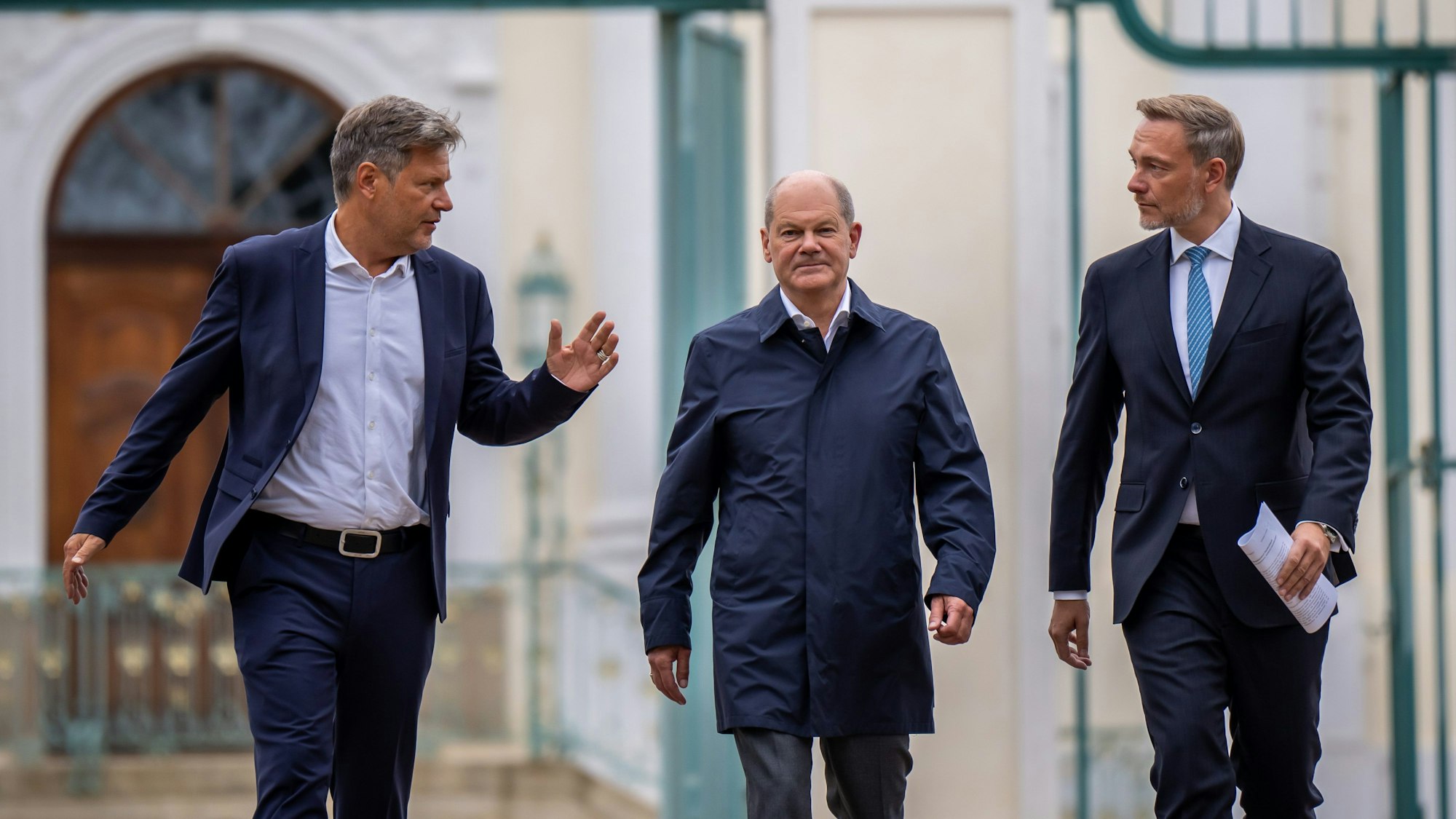 Bundeskanzler Olaf Scholz (SPD, M) kommt zwischen Christian Lindner (FDP, l), Bundesminister der Finanzen, und Robert Habeck (Bündnis 90/Die Grünen, r), Bundesminister für Wirtschaft und Klimaschutz, zum Pressestatement bei der Halbzeit-Klausur des Bundeskabinetts auf Schloss Meseberg.