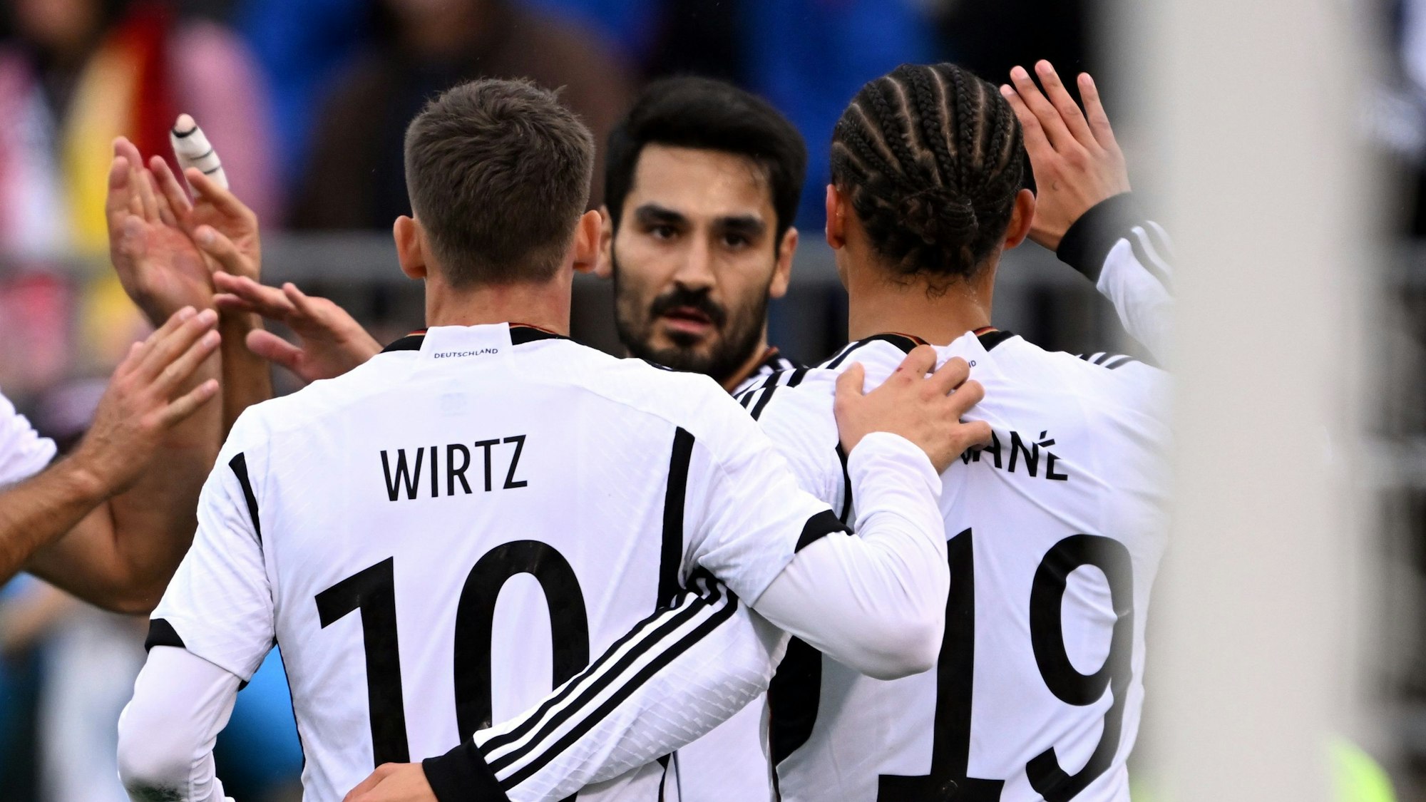 Florian Wirtz und Leroy Sané gratulieren Kapitän İlkay Gündoğan zum 1:1-Ausgleichstreffer.
