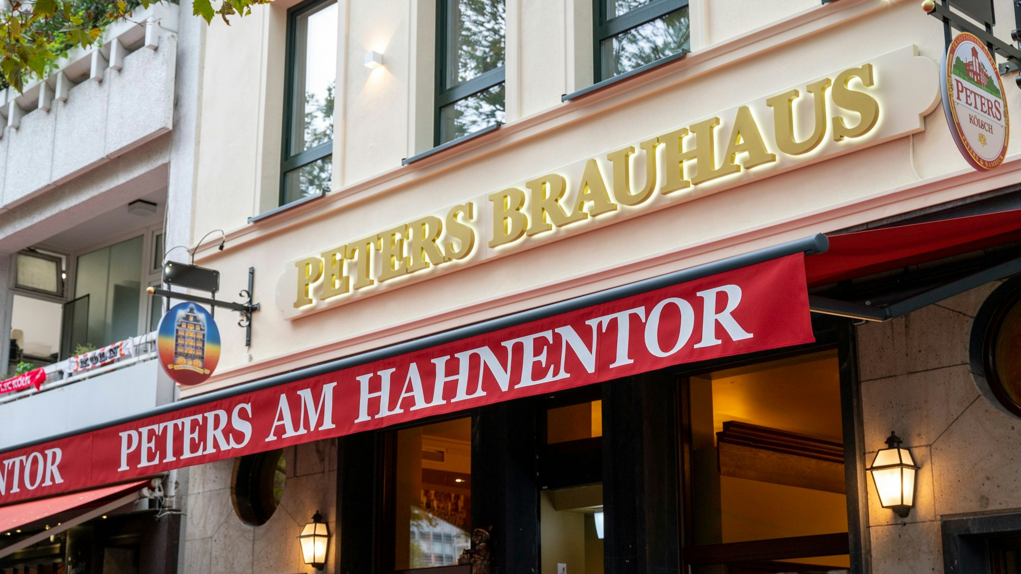 Die Fassade des neuen Peters-Brauhaus mit goldenen Lettern und roter Markise.
