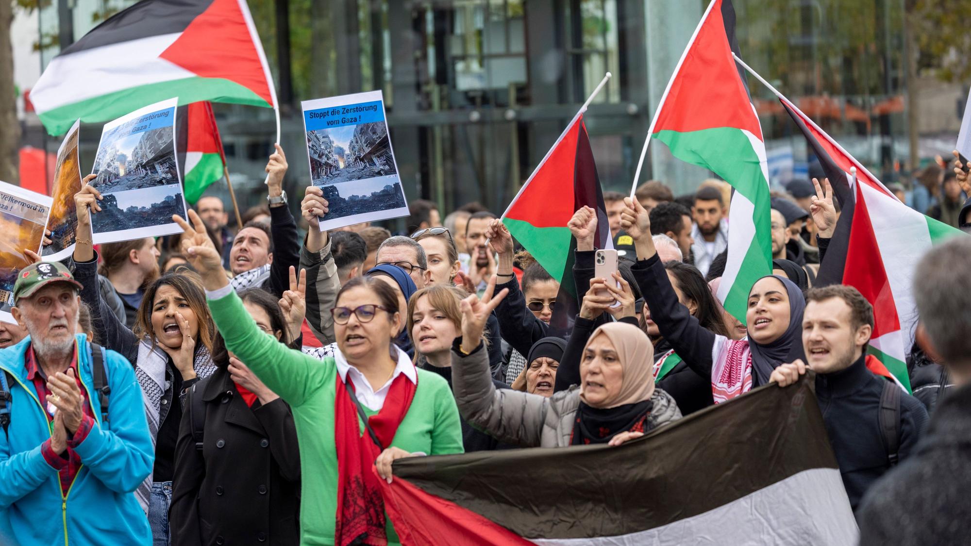 Teilnehmer einer Kundgebung unter dem Motto «Palästina unter Besatzung» stehen mit Fahnen auf dem Heumarkt und hören einem Redner zu.