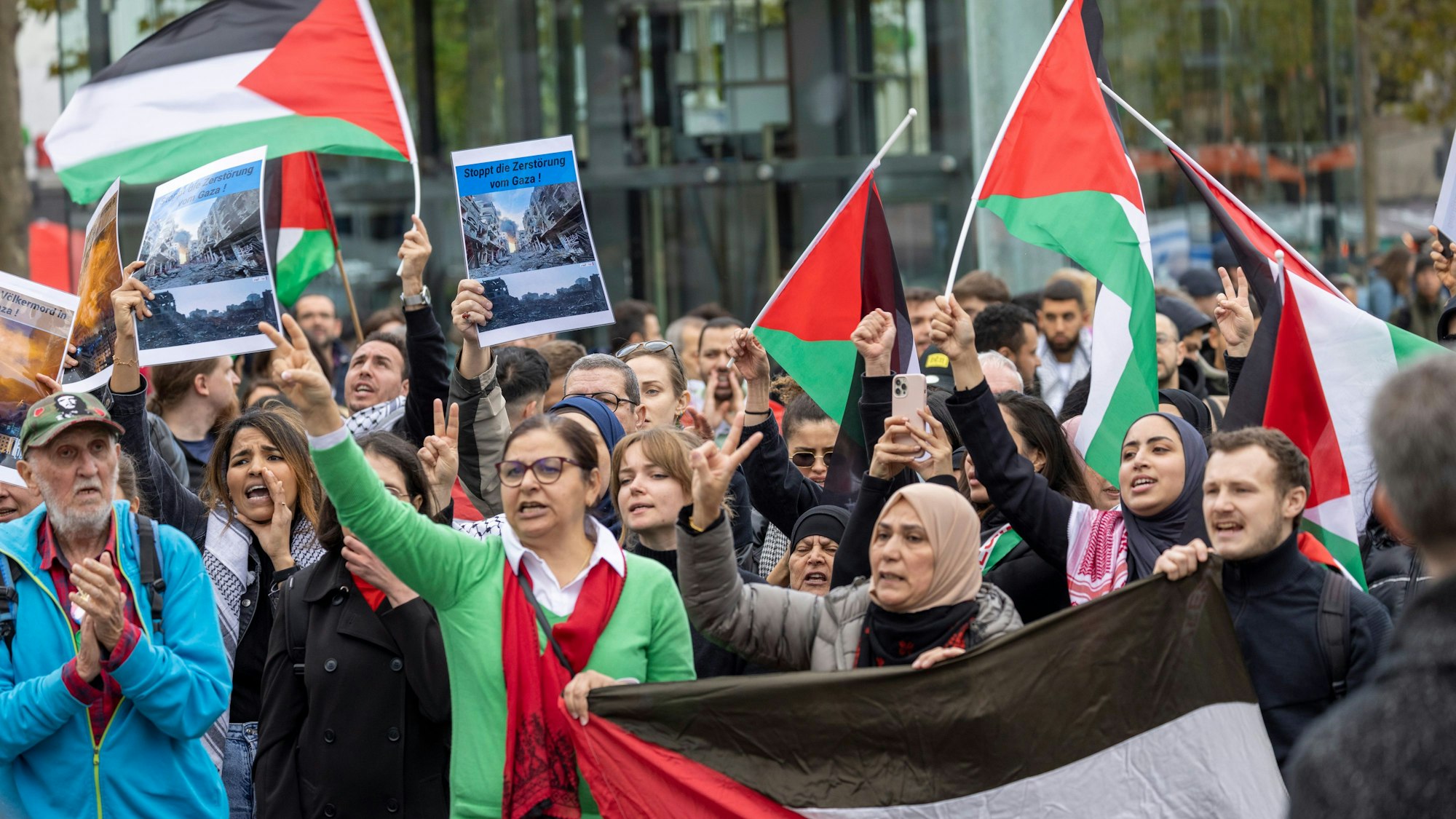 Teilnehmer einer Kundgebung unter dem Motto «Palästina unter Besatzung» stehen mit Fahnen auf dem Heumarkt und hören einem Redner zu.