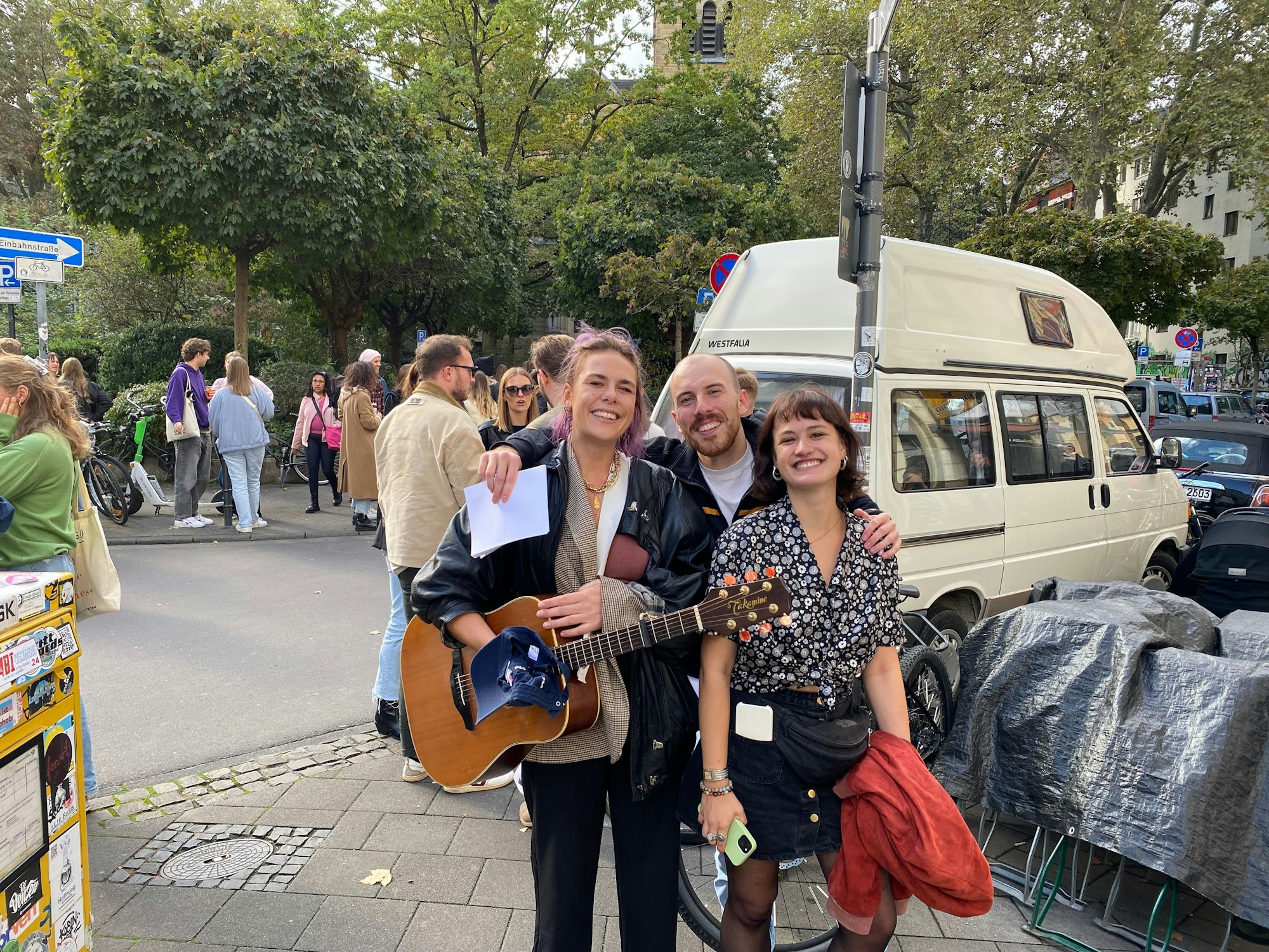 Ein fröhliches Trio posiert auf dem Bürgersteig für ein Foto.