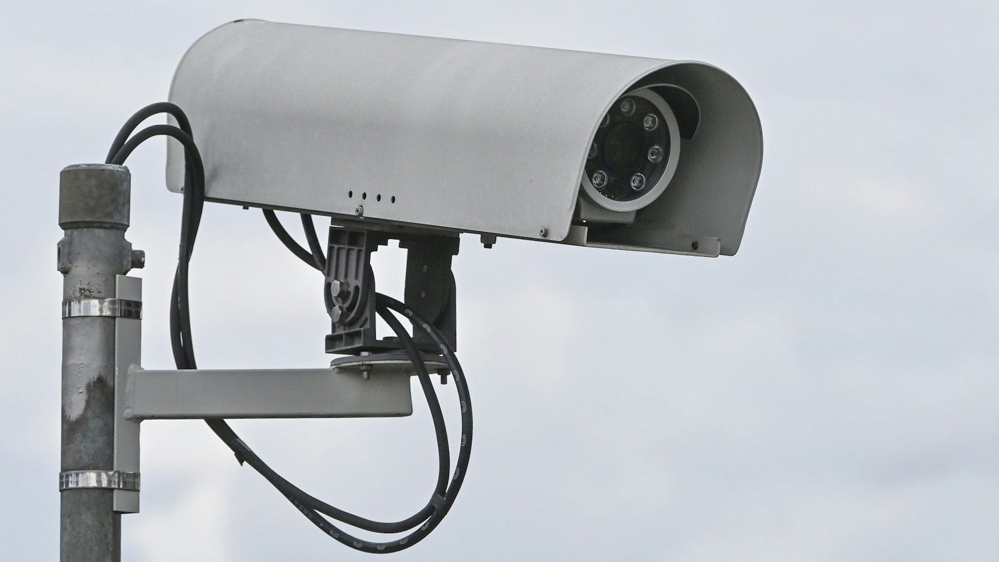 Eine Überwachungskamera vor bewölktem Himmel.