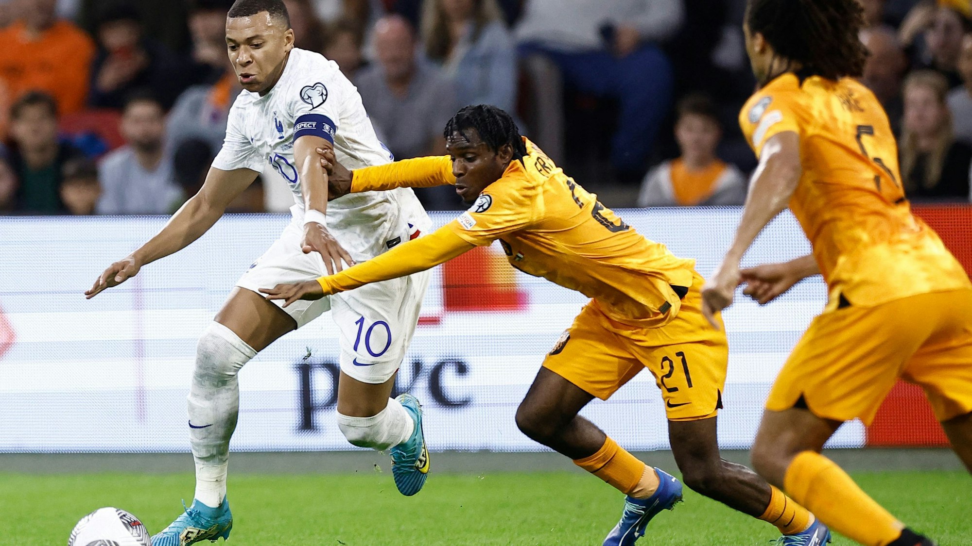 France's forward Kylian Mbappé (L) fights for the ball with Netherland's defender Jeremie Frimpong (C) during the Euro 2024 qualifying football match between the Netherlands and France at the Johan Cruijff ArenA in Amsterdam on October 13, 2023. (Photo by KENZO TRIBOUILLARD / AFP)