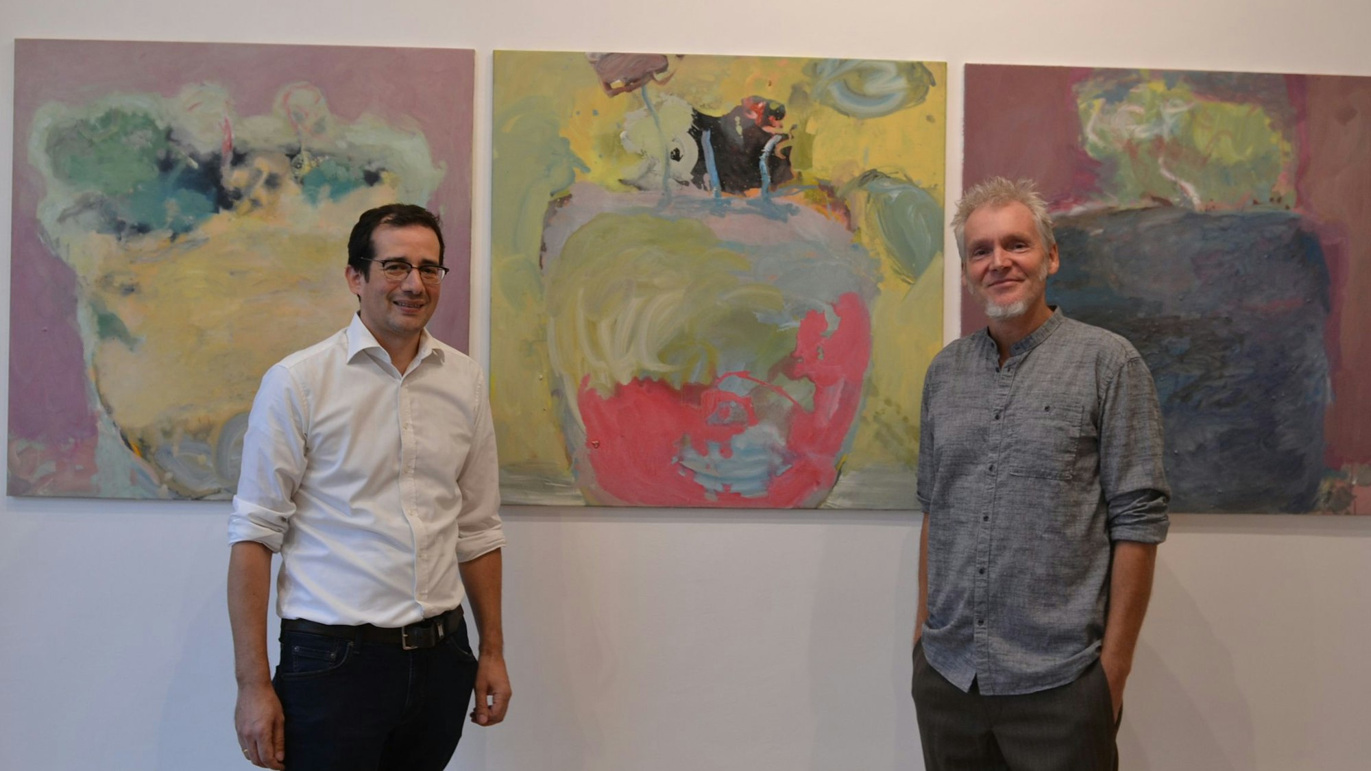 Galerist Stefan Hausen und Künstler Frank Bölter stehen vor einem der Kunstwerke.