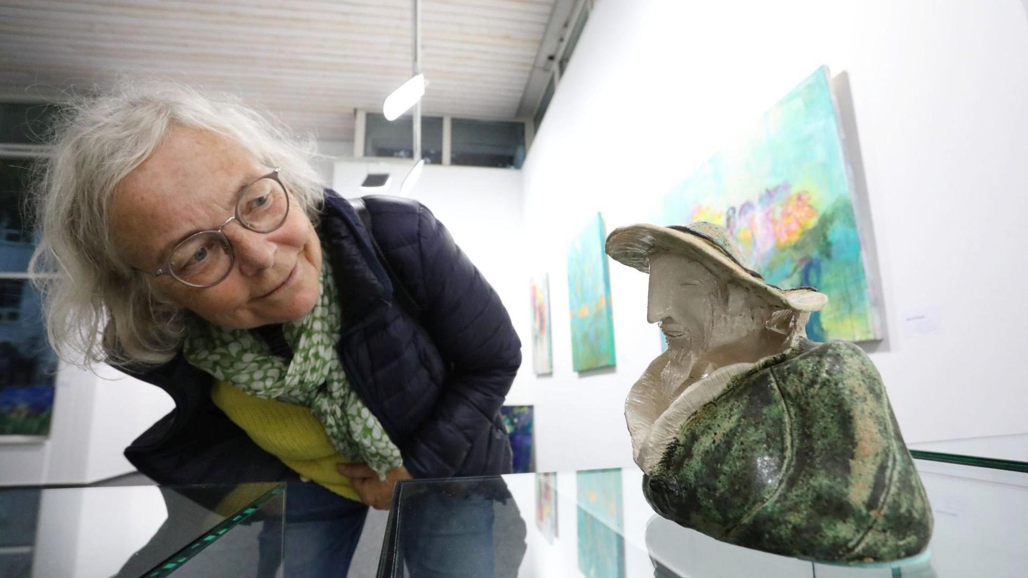 Eine Besucherin betrachtet eine Keramik von Wiltrud Bartmann im Kunstraum.