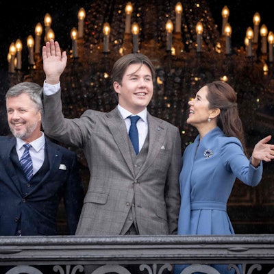Prinz Christian von Dänemark (m) winkt an seinem 18. Geburtstag aus einem Fenster von Schloss Amalienborg. An seiner Seite, sein Vater Kronprinz Frederik (l) und seine Mutter Kronprinzessin Mary (r).