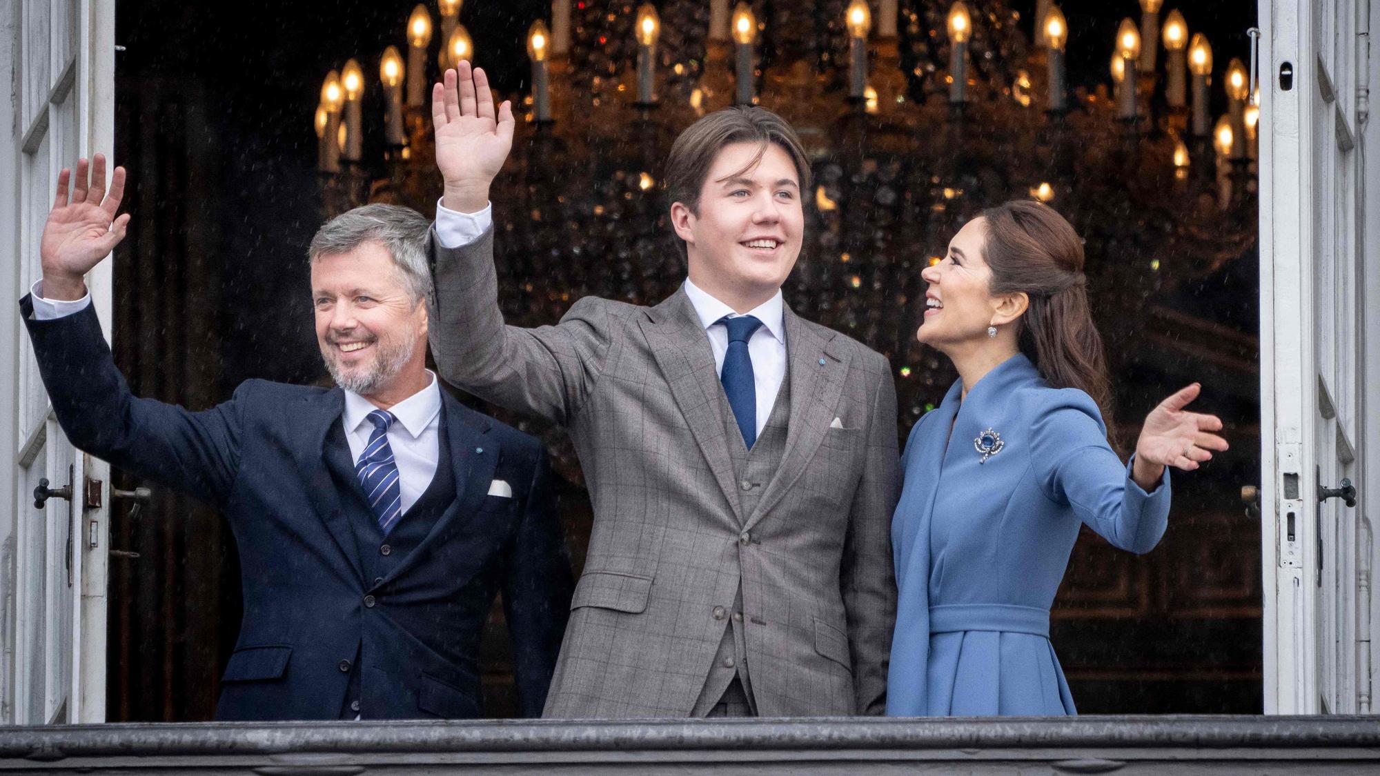 Prinz Christian von Dänemark (m) winkt an seinem 18. Geburtstag aus einem Fenster von Schloss Amalienborg. An seiner Seite, sein Vater Kronprinz Frederik (l) und seine Mutter Kronprinzessin Mary (r).