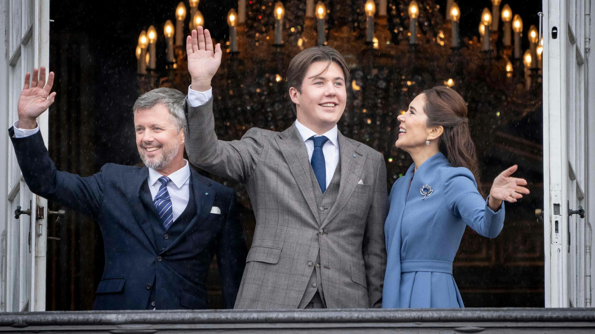 Prinz Christian von Dänemark (m) winkt an seinem 18. Geburtstag aus einem Fenster von Schloss Amalienborg. An seiner Seite, sein Vater Kronprinz Frederik (l) und seine Mutter Kronprinzessin Mary (r).