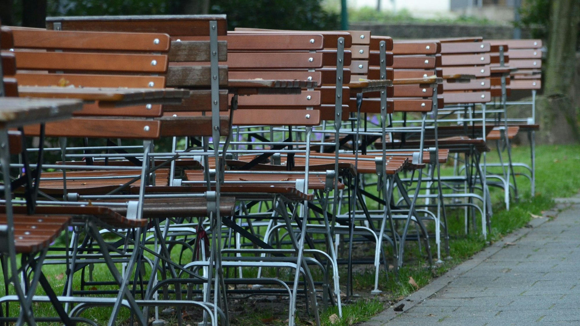 Kneipenstühle stehen an einer Straße.