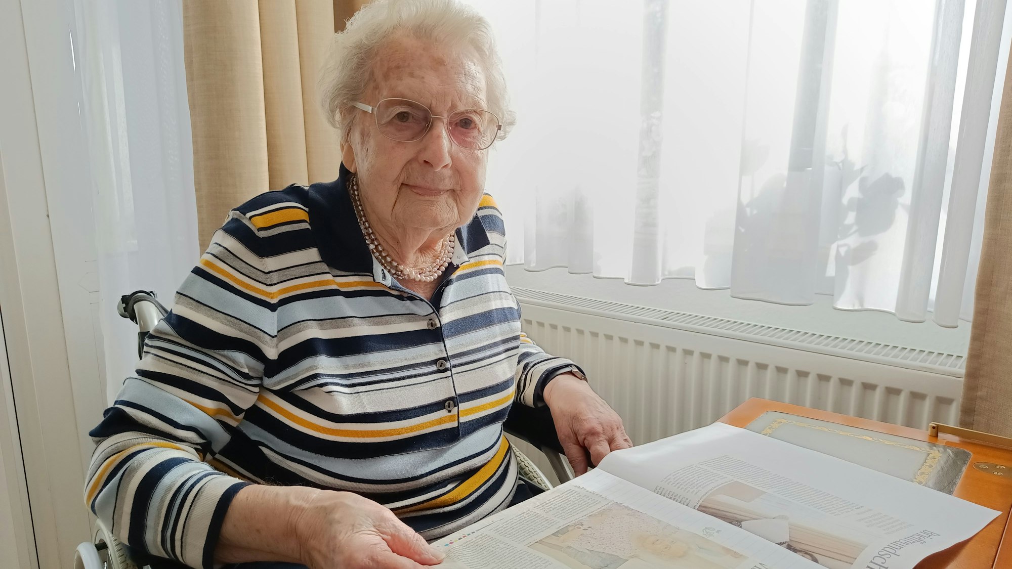 Die Gratulantin sitzt an ihrem Schreibtisch.