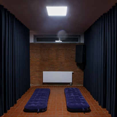 Zwei Luftmatratzen in einem karg aussehenden Raum im Souterrain.