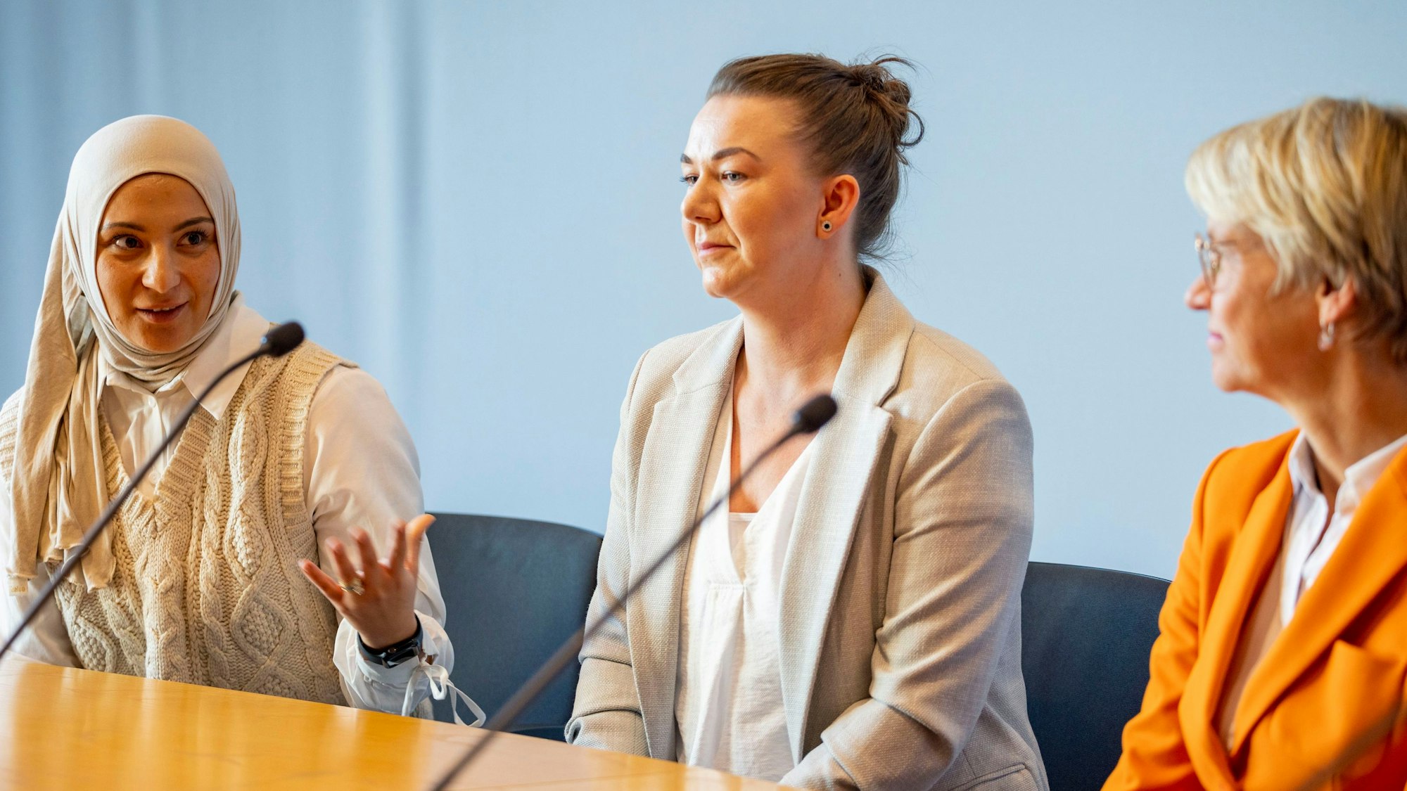 16.10.2023, Nordrhein-Westfalen, Düsseldorf: Schulministerin Dorothee Feller (r) spricht bei einer Pressekonferenz zur Verbesserung der Unterrichtsversorgung mit den Alltagshelferinnen Kübra Kacar (l) und Yvonne Dominas aus Gelsenkirchen-Schalke. Foto: Christoph Reichwein/dpa +++ dpa-Bildfunk +++