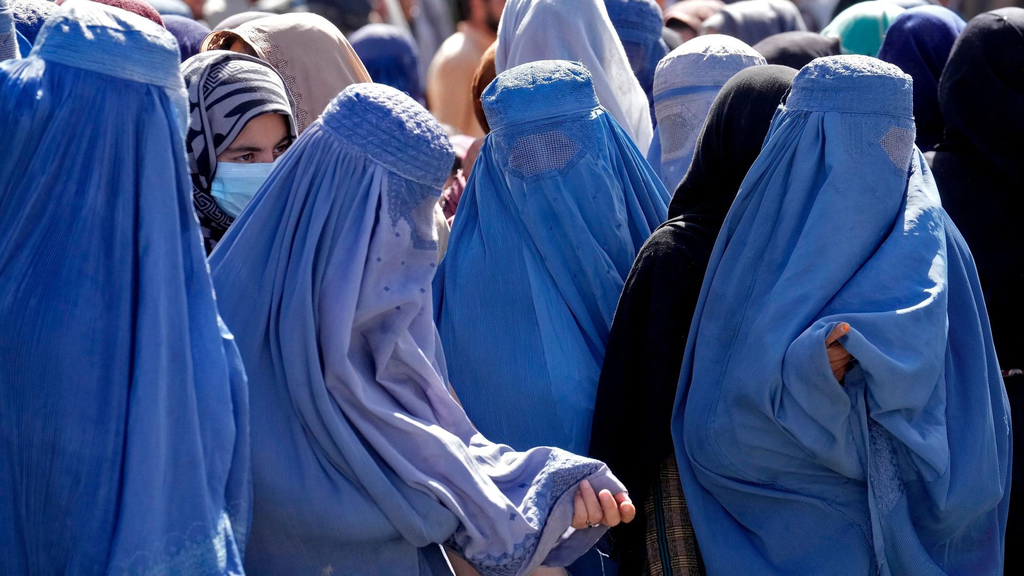 Frauen in Burkas warten auf Lebensmittelrationen, die von einer humanitären Hilfsorganisation verteilt werden. (Archivbild)