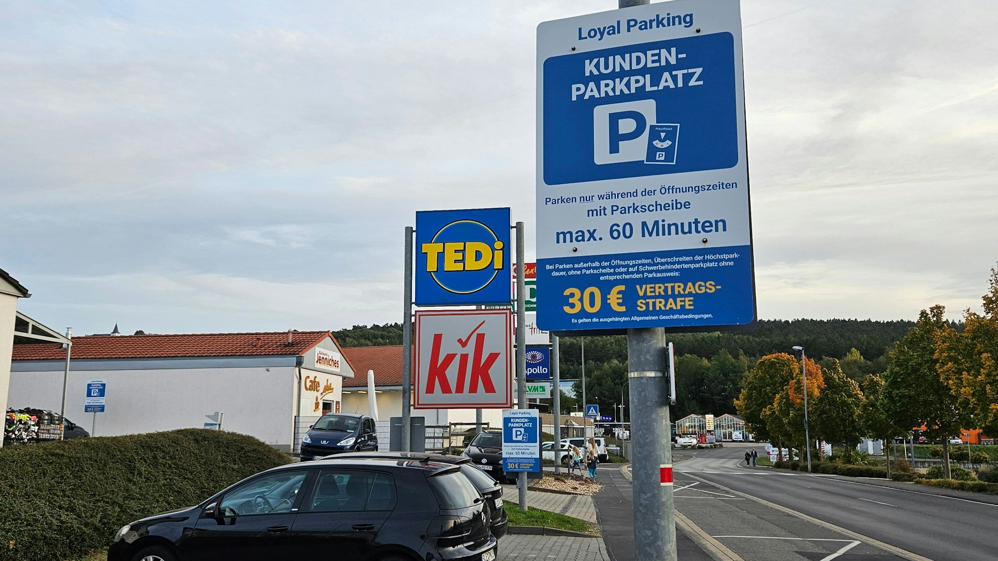 Ein Schild weist auf die maximale Parkzeit von 60 Minuten und die Vertragsstrafe von 30 Euro hin. Im Hintergrund sind die Schilder von Tedi und Kik zu sehen.
