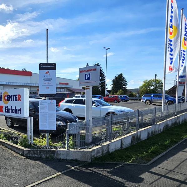 Blick auf den Parkplatz mit den Geschäften im Hintergrund.