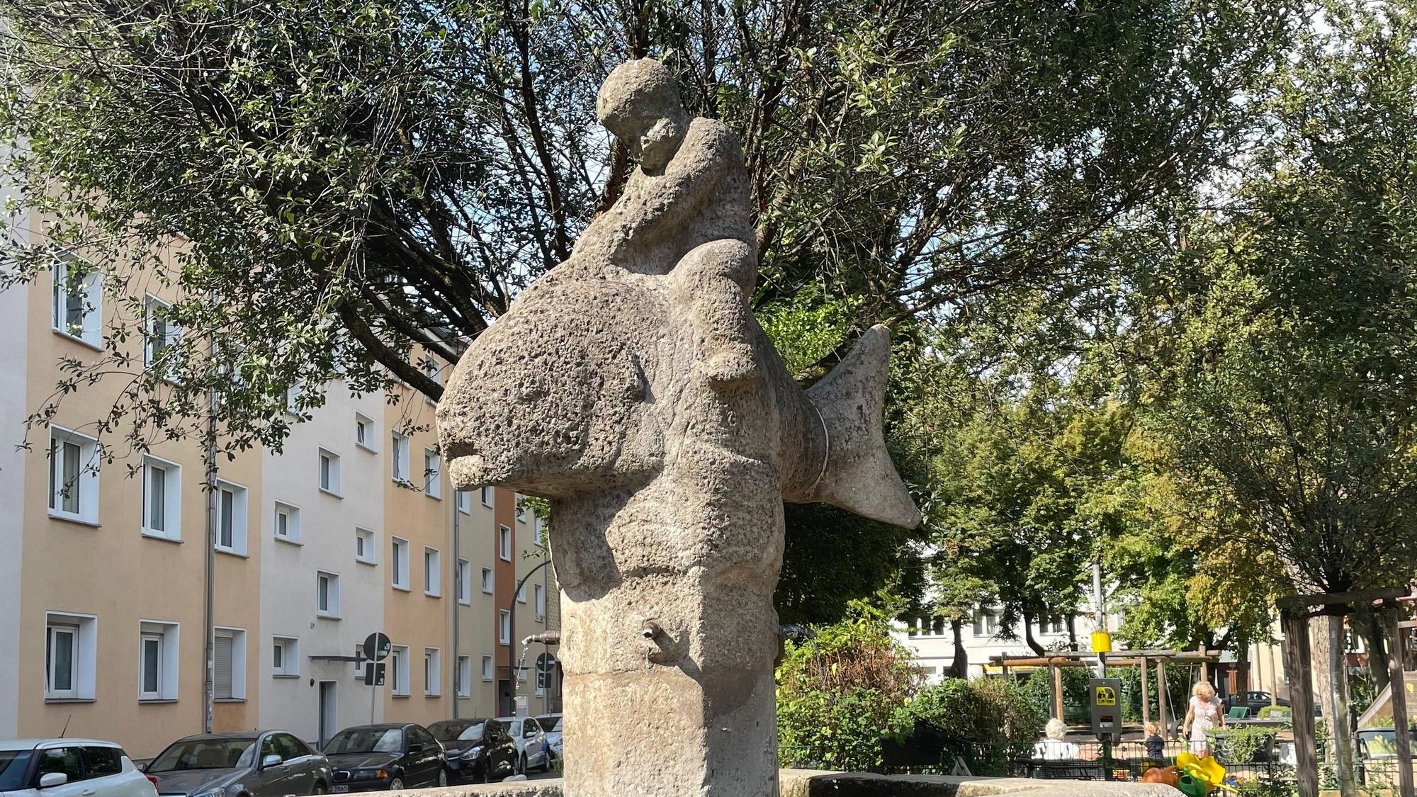 Ein Brunnen, der einen Jungen zeigt, der auf einem Fisch reitet.