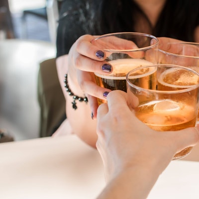 Personen stoßen mit alkoholischen Getränken an. Laut einer neuen Empfehlung der Deutschen Hauptstelle für Suchtfragen ist jeder Alkoholkonsum schädlich, auch in kleinen Mengen. (Symbolbild)