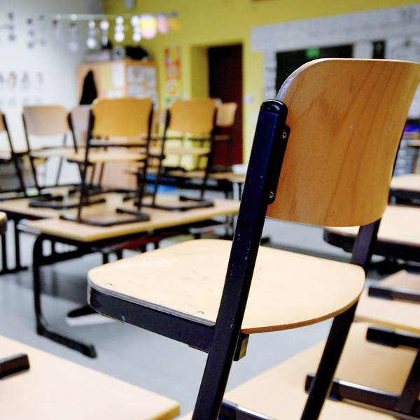 Stühle stehen in einem Klassenzimmer in einer Grundschule auf den Tischen.