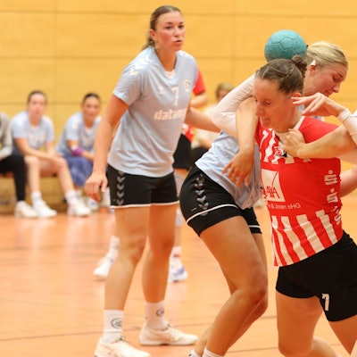Eine Handballspielerin wird von zwei Gegenspielerinnen gestoppt.