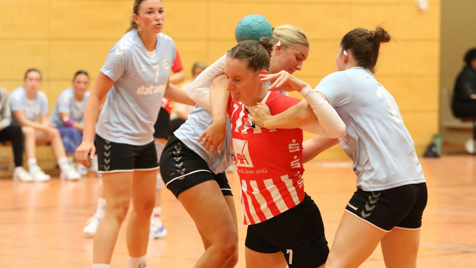 Eine Handballspielerin wird von zwei Gegenspielerinnen gestoppt.