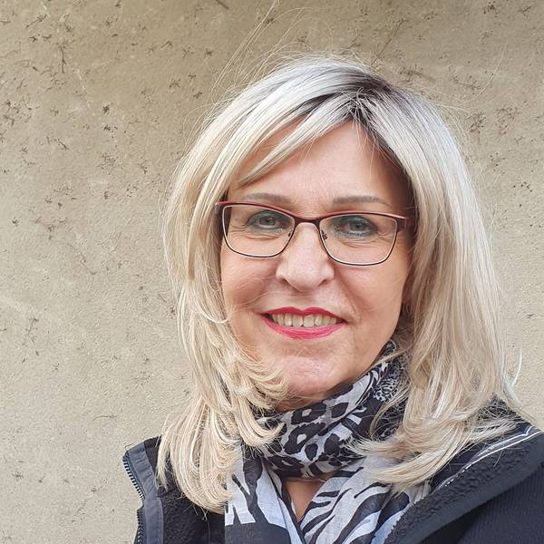 Eine Frau lächelt in die Kamera.