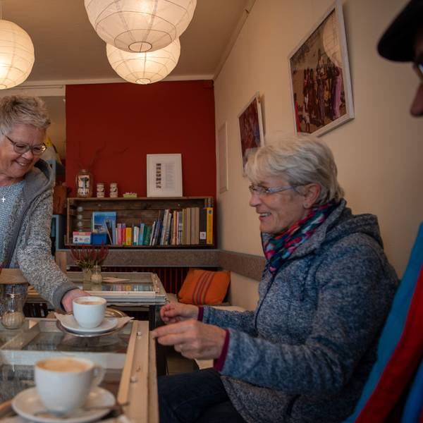 Monika Geißler serviert im Fair-Café in Zülpich einer Besucherin eine Tasse Kaffee.