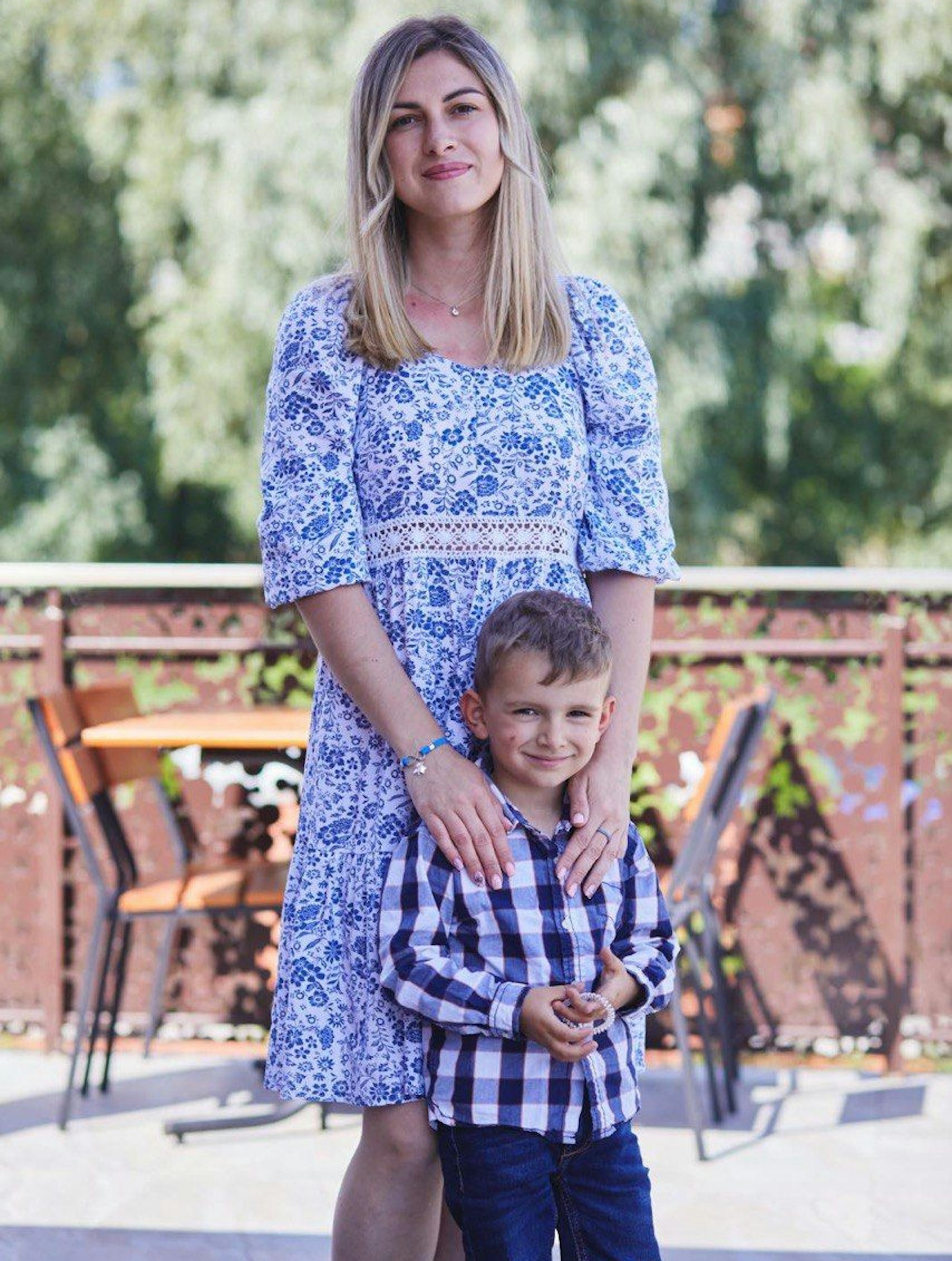 Eine Frau im Kleid steht mit einem Junge