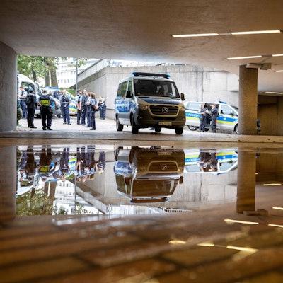 Polizisten und Streifenwagen stehen auf dem Ebertplatz vor dem Zugang zur Zwischenebene der KVB.