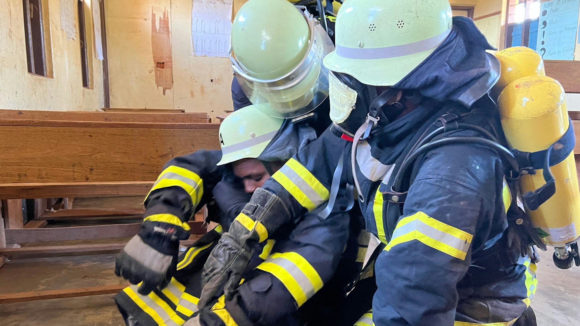 Ein Atemschutztrupp der Feuerwehr rettet einen dritten Feuerwehrmann.