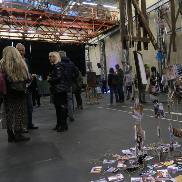 In einer großen Halle flanieren Besucher zwischen Kunstwerken.