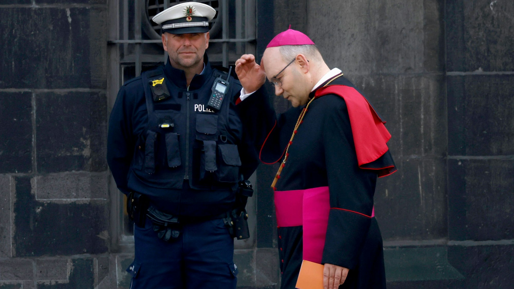 Der Aachener Bischof Helmut Karl Dieser geht vorbei an Polizisten vorbei. (Archivbild)