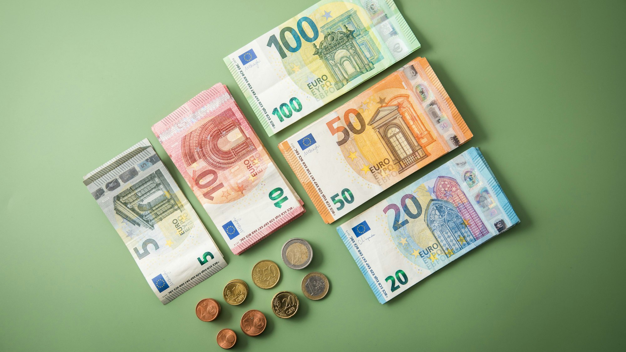 Geldscheine, Euro und Cent-Münzen ordentlich gestapelt.