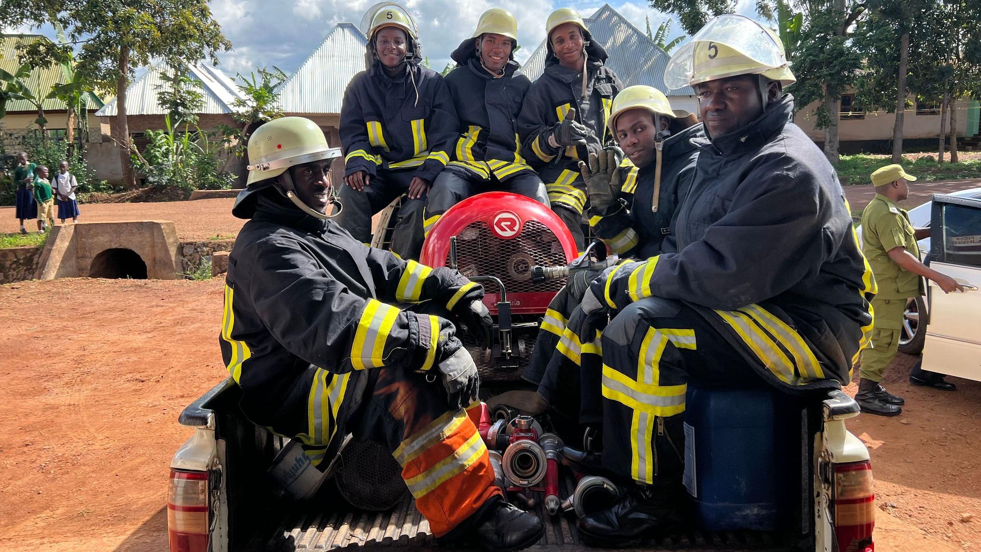 Foto von sechs Feuerwehrmännern mit Gerätschaften auf der Ladefläche eines Pick-ups.