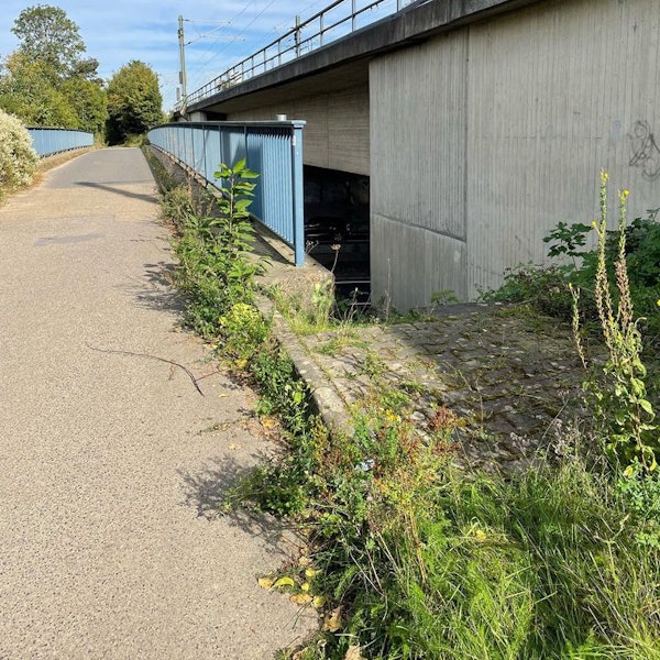 Das Bild zeigt einen Weg an der Autobahn, der zur Fahrbahn führt.