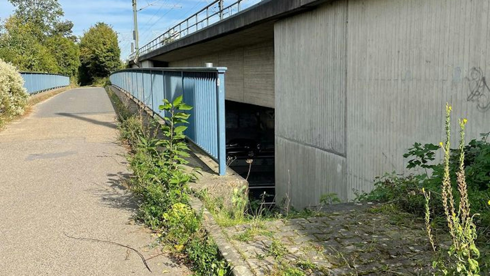 Das Bild zeigt einen Weg an der Autobahn, der zur Fahrbahn führt.