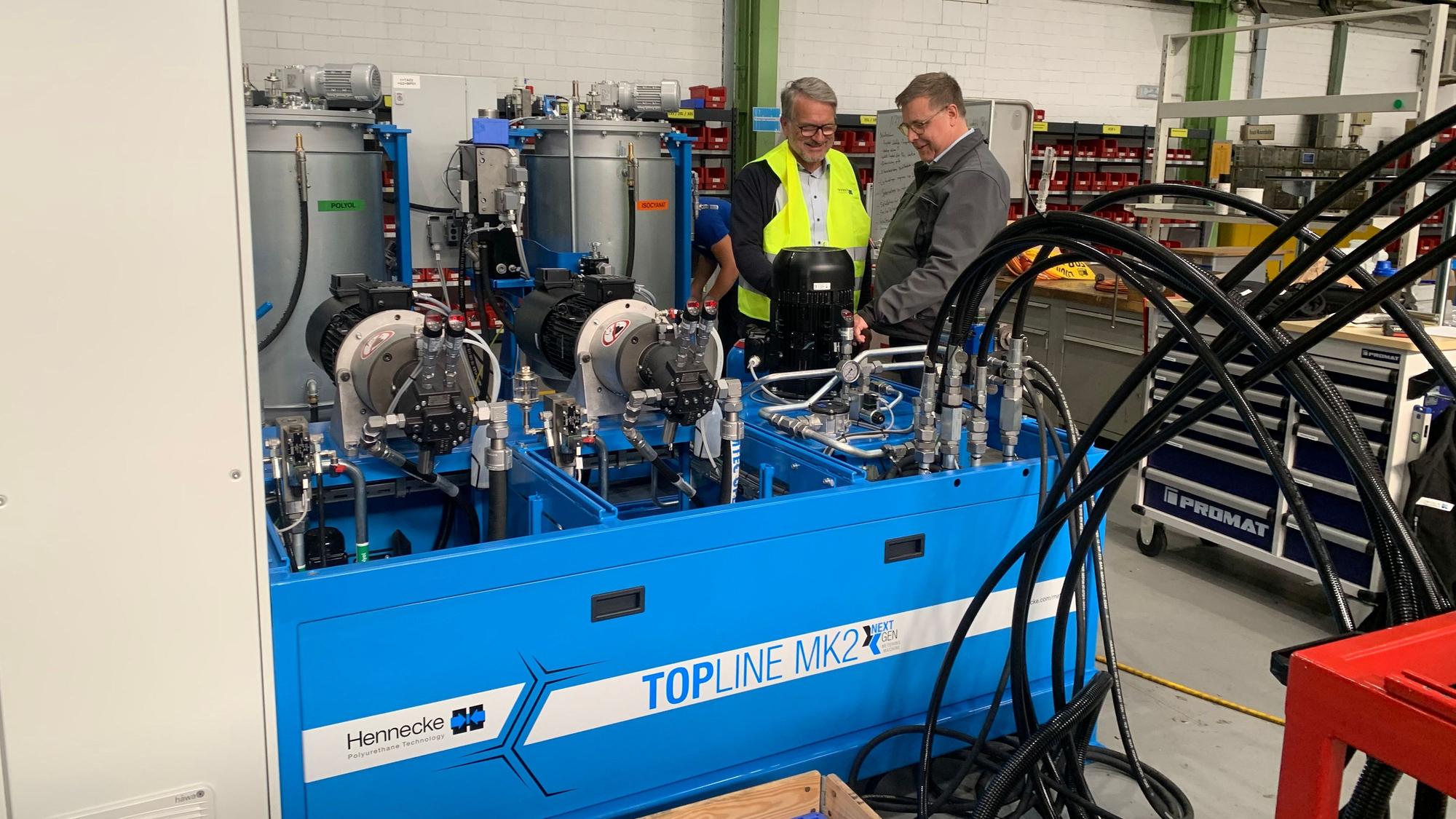 Thomas Wildt (l.), CEO Hennecke, im Gespräch mit Christian Fuchs, Produktionsleiter Werk Sankt Augustin, an der neuen Hochdruck-Dosiermaschine Topline MK2