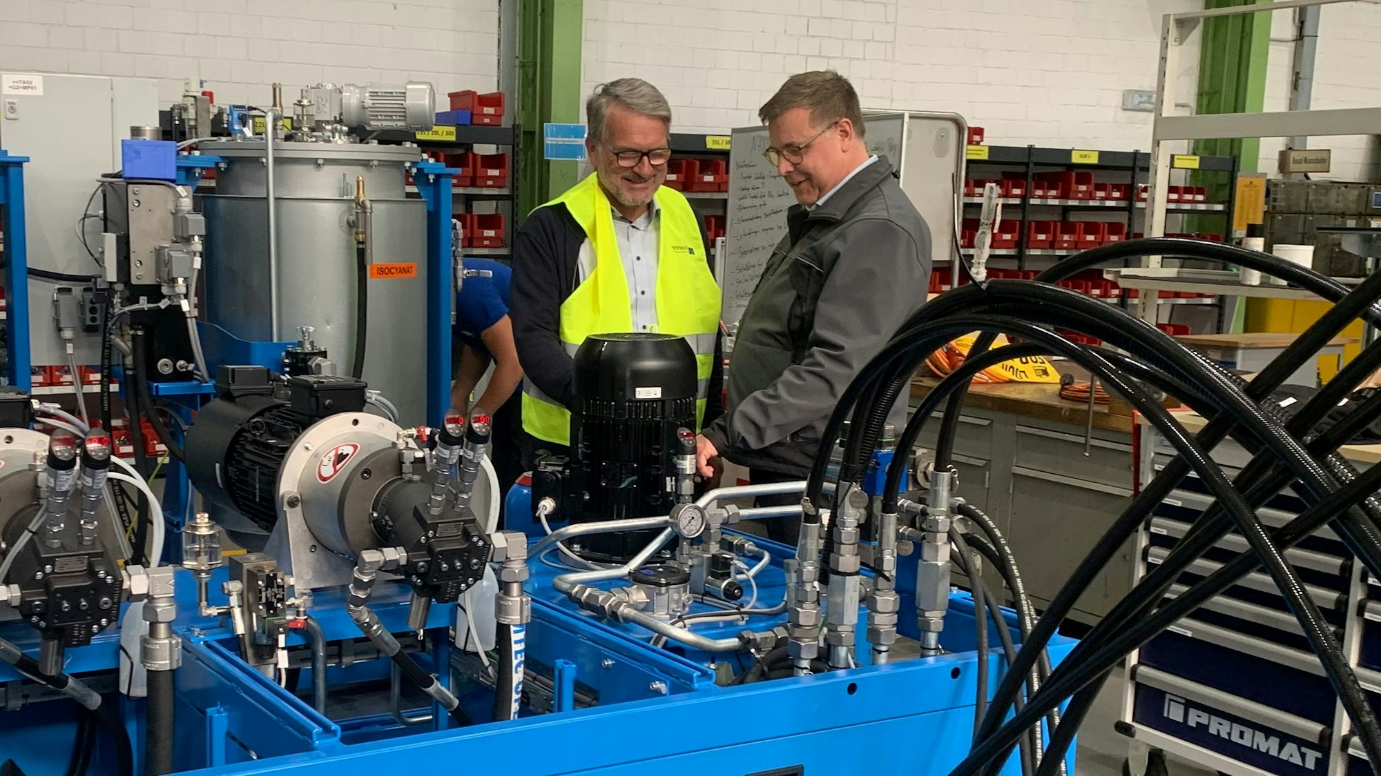 Zwei Männer an einer Maschine.