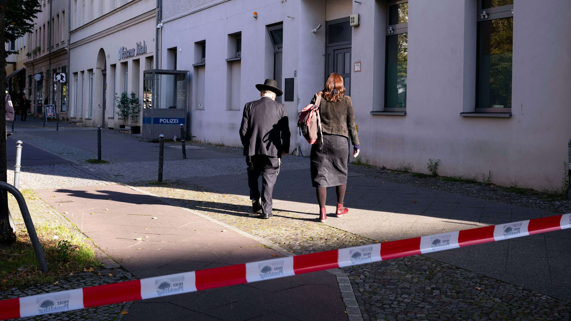 People enter the building complex of the Kahal Adass Jisroel community, which houses a synagogue, a kindergarten and a community center, in the center of Berlin, Germany, Wednesday, Oct. 18, 2023. The Kahal Adass Jisroel community said its synagogue in the city's Mitte neighborhood was attacked with two incendiary devices. Police confirmed the incident. (AP Photo/Markus Schreiber)