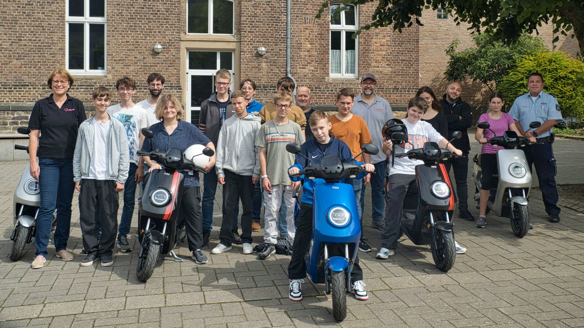 Die Schüler der Realschule in Bad Münstereifel stehen vor dem Schuleingang und posieren auf ihren Mofas.