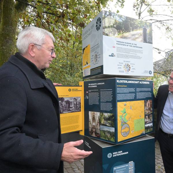 Unter anderem Landrat Stephan Santelmann und Bürgermeister Robert Lennerts schauen auf die Infotafel des Wanderweges.