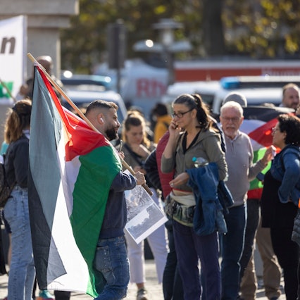 Menschen mit Palästina-Fahnen stehen auf dem Kölner Heumarkt