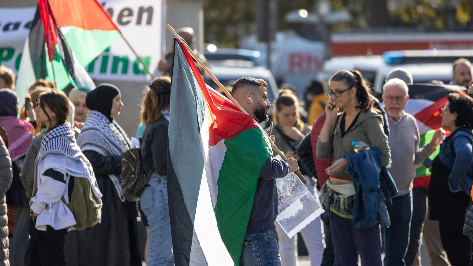 Menschen mit Palästina-Fahnen stehen auf dem Kölner Heumarkt