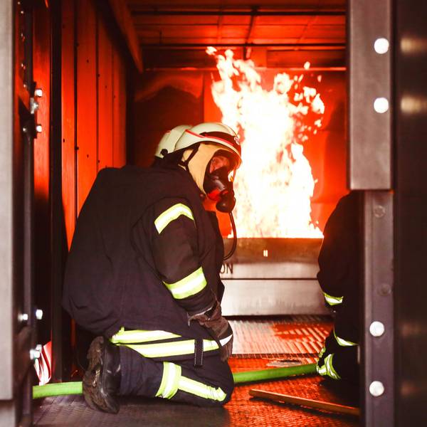 Feuerwehrleute mit Atemschutzmaske im Brandübungscontainer der Feuerwehr Köln.