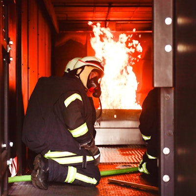 Feuerwehrleute mit Atemschutzmaske im Brandübungscontainer der Feuerwehr Köln.